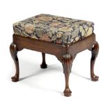 A GEORGE II MAHOGANY STOOL C.1740 the later needlework drop-in seat above a shaped frieze, on