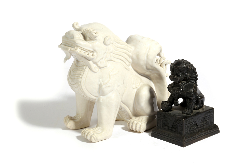 A CHINESE BRONZE MODEL OF A LION DOG 19TH CENTURY sporting a bell, seated on a rectangular plinth,