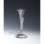 A composite stem wine glass c.1755, the bell bowl with a solid base, beginning an airtwist stem over