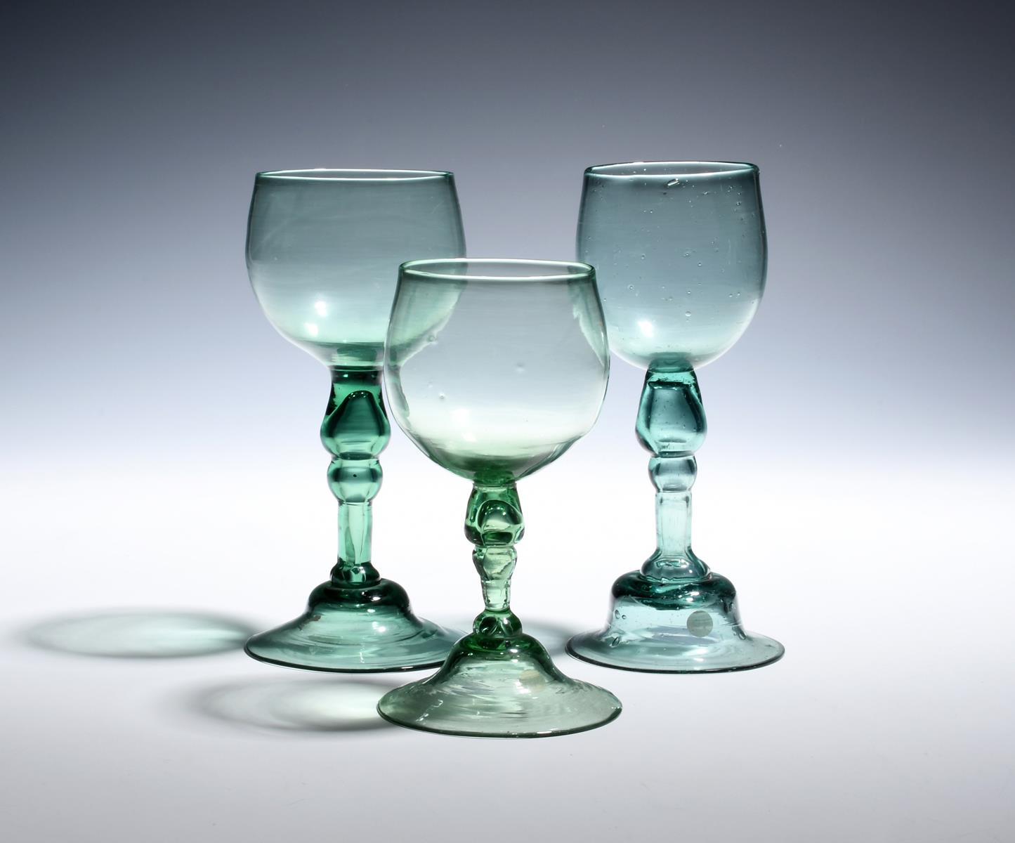 Three export green wine glasses c.1760, the cup bowls of a pale tone, raised on hollow blown stems