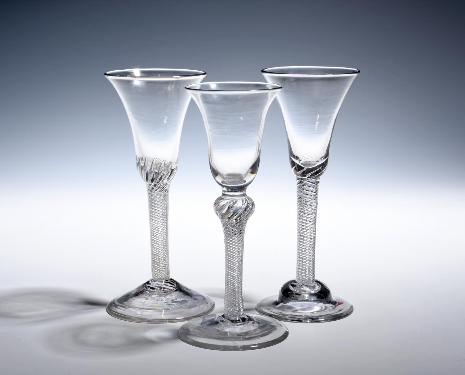 Three wine glasses c.1750-60, with bell bowls, raised on dense airtwist stems, one with a shoulder