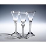 Three wine glasses c.1750-60, with bell bowls, raised on dense airtwist stems, one with a shoulder