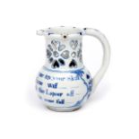 A Liverpool delftware puzzle jug c.1740-60, the squat body inscribed with a four line wager inviting