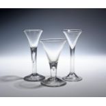 Three wine glasses c.1750-60, with drawn trumpet bowls over plain stems, two enclosing long tears,