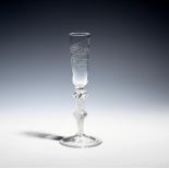 A rare ratafia glass or toasting flute c.1760-80, the slender bowl engraved with a banner