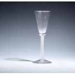 A wine glass c.1760, with an elongated round funnel bowl raised on a dense airtwist stem beneath two