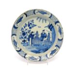 A Bristol delftware shallow dish c.1740, painted in blue with a Chinese lady in a garden being