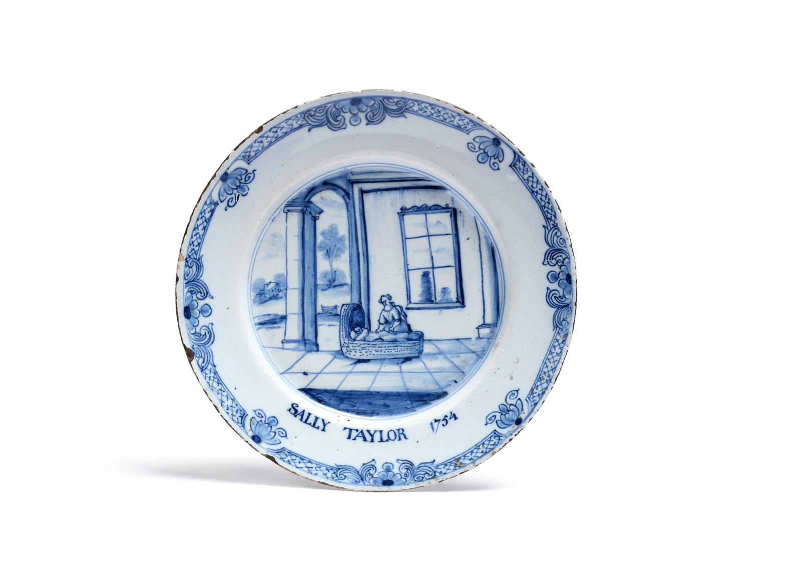 A documentary delftware plate dated 1754, painted in blue with a mother tending a child in a large