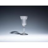 A small wine glass c.1760, with a slender flared bucket bowl engraved with a band of fruiting