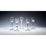 Five wine glasses c.1750-60, two with round funnel bowls and one with an ogee bowl, all raised on