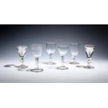 Two deceptive glasses c.1820, with funnel bowls raised on knopped stems, and four other wine glasses