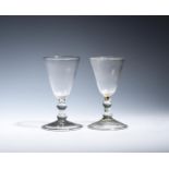 Two balustroid wine glasses c.1740, with deep round funnel bowls, raised on knopped stems above