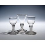 Three firing glasses c.1750-60, one with a moulded ogee bowl, another with a round funnel bowl, both