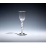 A wine glass c.1760, with a round funnel bowl raised on a multi-knopped airtwist stem above a