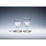 Two firing glasses c.1760, with ogee bowls, one moulded with flutes to the base, both raised on