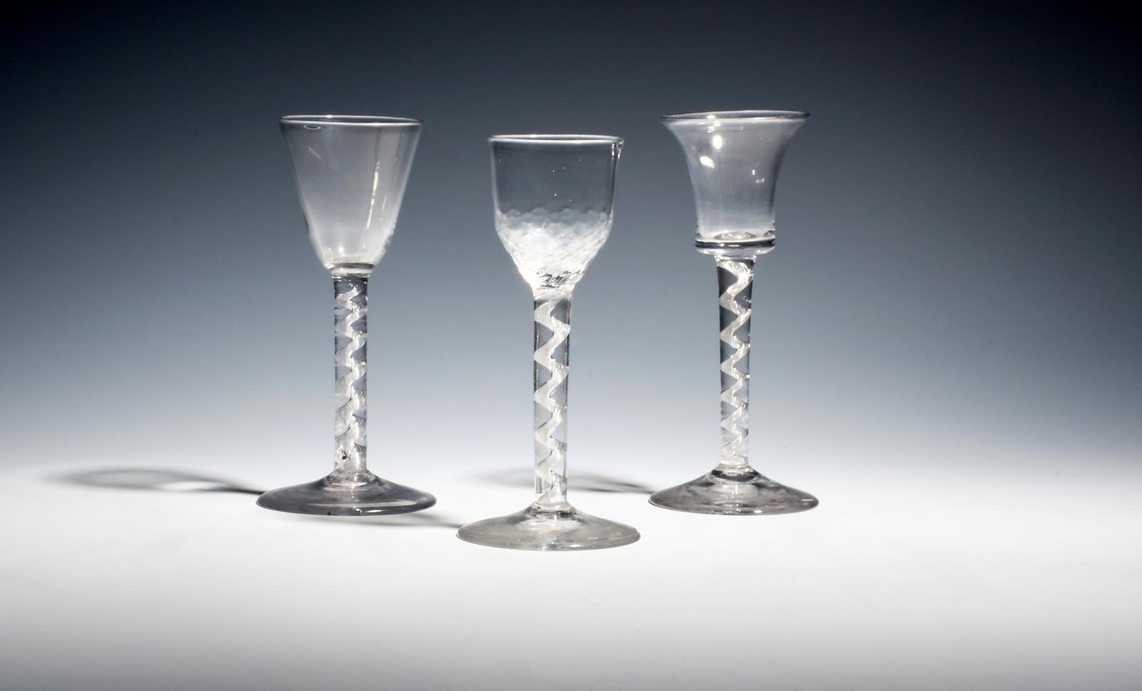 Three small wine glasses c.1760, with round funnel, bell and hammered bowls, all raised on cable