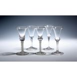 Five Continental wine glasses mid 18th century, with bell bowls, two raised on plain stems, one on