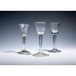 A gin glass and two small wine glasses c.1730-40, the gin with a bell bowl over a folded foot, the