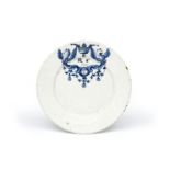 A Delft plate dated 1690, painted in blue with a cartouche flanked by mythical creatures and