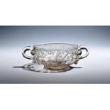 A glass two-handled porringer early 18th century, the shallow bowl with moulded gadrooning beneath