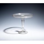 A tall glass tazza c.1740, the flat circular top with a galleried rim, raised on a bobbin stem of