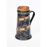 A Doulton Lambeth stoneware jug probably by George Tinworth, tapering cylindrical form, incised with