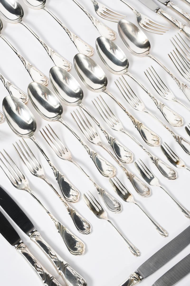 An Art Nouveau silver-plated twelve setting cutlery service, cast in low relief with whiplash