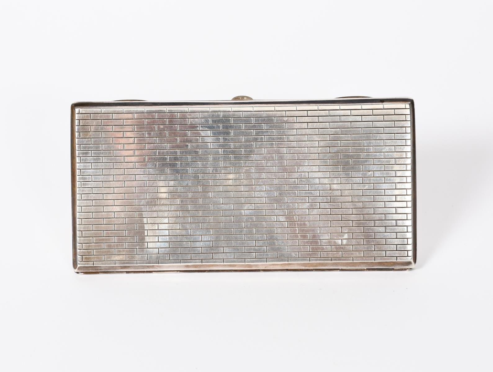 An Omar Ramsden silver cigarette case, rectangular, the case with simple geometric decoration,