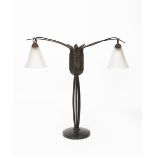 An Art Deco wrought iron two-light lamp in the manner of Edgar Brandt, the central clustered stem