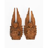 A pair of carved oak angels the design attributed to Peter Paul Pugin, each modelled holding a