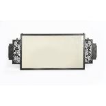 An Art Deco patinated wrought iron wall mirror in the manner of Edgar Brandt, rectangular frame,