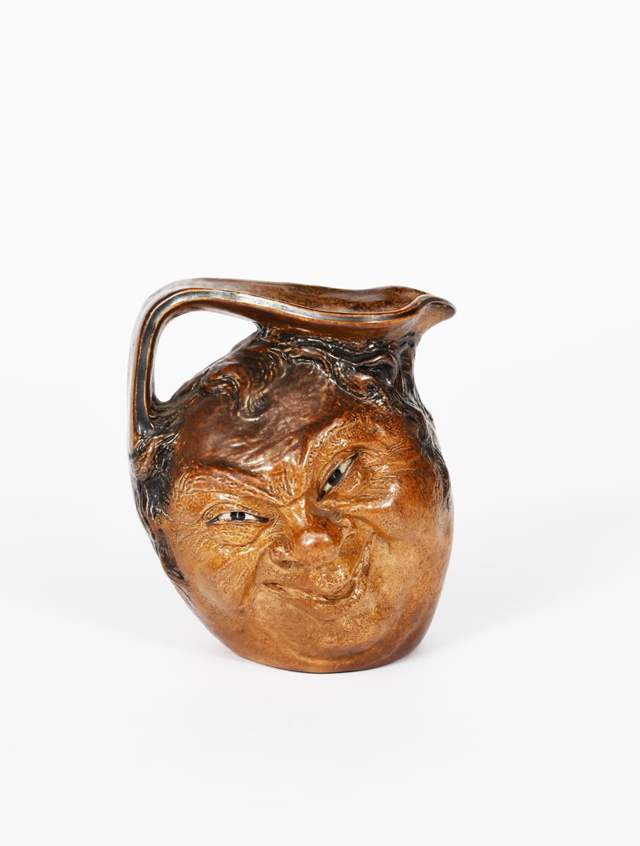 A Martin Brothers stoneware face jug by Robert Wallace Martin, dated 1912, modelled with a smiling