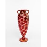 A tall twin-handled vase probably Maw & Co, slender, footed form, painted with a floral repeat in