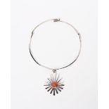 An English silver necklace, the cast sun motif pendant set with red cabochon, on articulated collar,