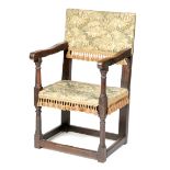 A CHARLES II OAK AND UPHOLSTERED ARMCHAIR C.1670-80 the back seat and cushion later covered in a