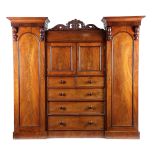 A VICTORIAN MAHOGANY COMBINATION WARDROBE C.1870 with a scroll carved cresting and applied with
