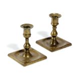 A PAIR OF GEORGE III BRASS DWARF CANDLESTICKS C.1760 of seamed construction, each with an urn socket