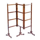 A REGENCY MAHOGANY FOLDING CLOTHES HORSE EARLY 19TH CENTURY twin hinged with three rails on scroll