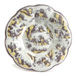 A DELFT POTTERY LOBED DISH C.1700 painted in manganese and yellow, with Chinese figures and