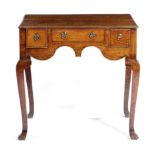 A GEORGE II OAK LOWBOY C.1730-40 fitted with three frieze drawers above a wavy edge apron, on square