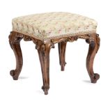 A VICTORIAN OAK STOOL C.1860 the later silk upholstered seat above a carved scroll frieze and