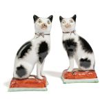 A PAIR OF STAFFORDSHIRE POTTERY MODELS OF CATS C.1860 each painted with black spots and a gilt