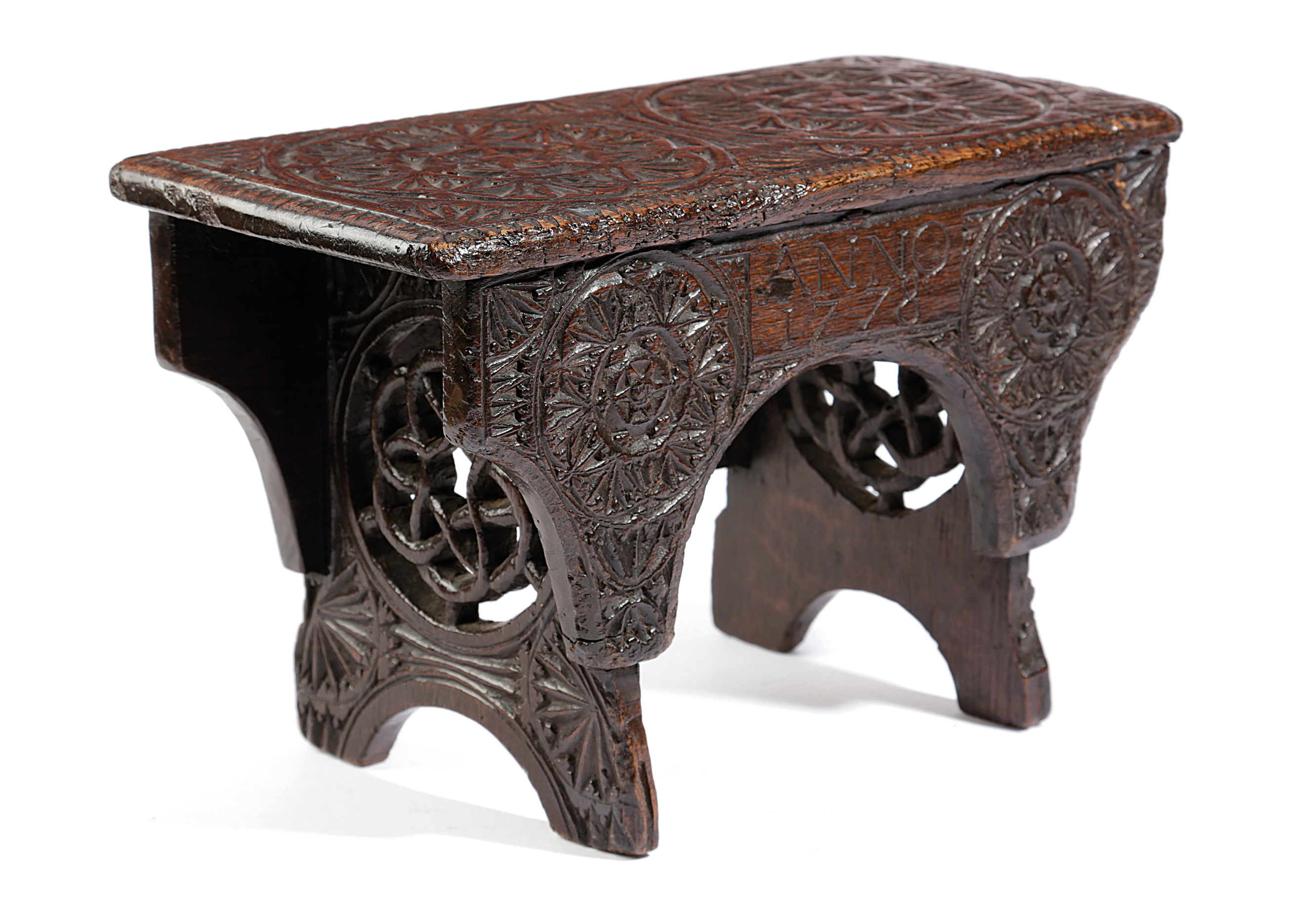 A GEORGE III CHIP CARVED STOOL WELSH, DATED '1778' relief decorated with rondels, the trestle ends