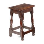 A CHARLES II OAK JOINT STOOL C.1660 with a rectangular seat above a moulded frieze, on turned