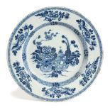 A DELFTWARE POTTERY BLUE AND WHITE CHARGER MID-18TH CENTURY painted in Chinese style, with a vase of