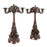 A PAIR OF CARVED OAK THREE-LIGHT CANDELABRA 19TH CENTURY each with a fluted stem issuing leaf and
