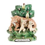 A STAFFORDSHIRE PEARLWARE POTTERY GROUP OF ROMULUS AND REMUS EARLY 19TH CENTURY with a bocage raised