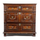 A CHARLES II OAK CHEST C.1680 the rectangular top above a stylized dentil cornice and applied