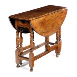 A QUEEN ANNE OAK GATELEG TABLE EARLY 18TH CENTURY the oval drop-leaf top on bobbin, disc and