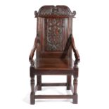 A CHARLES II PANELLED BACK ARMCHAIR C.1660 the scroll top rail centred with a fleur-de-lis motif,